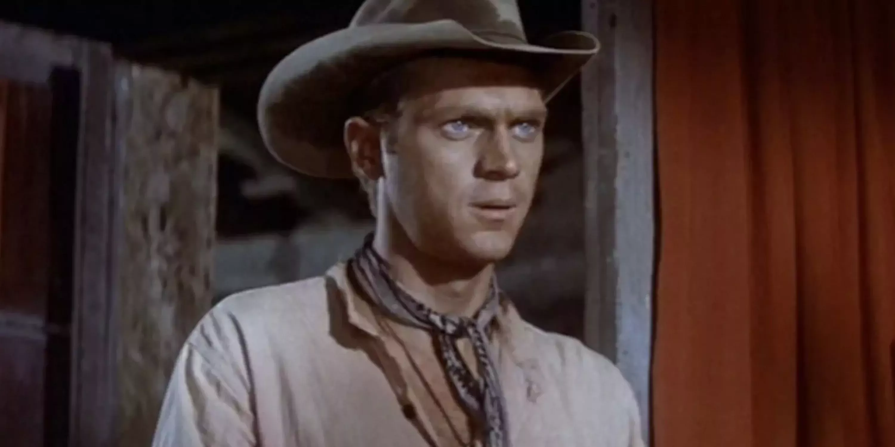 Vin Tanner played by Steve McQueen stands in a doorway