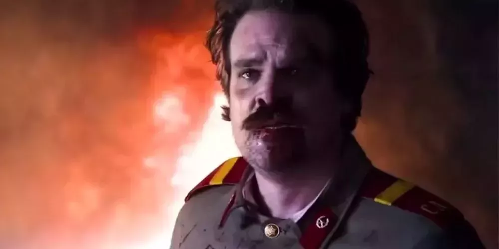 Hopper with tears in his eyes in front of a red background - Stranger Things 3