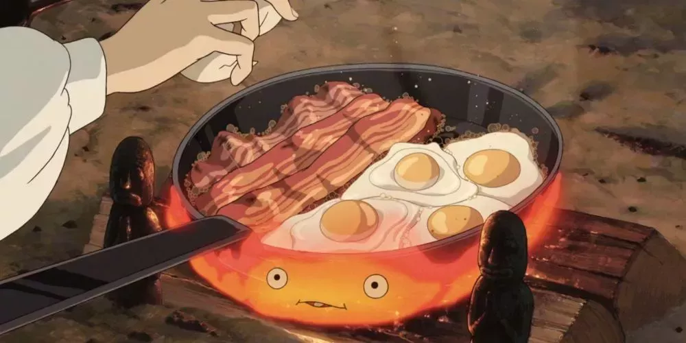 Calcifer from Howl's Moving Castle cookiong bacon and eggs