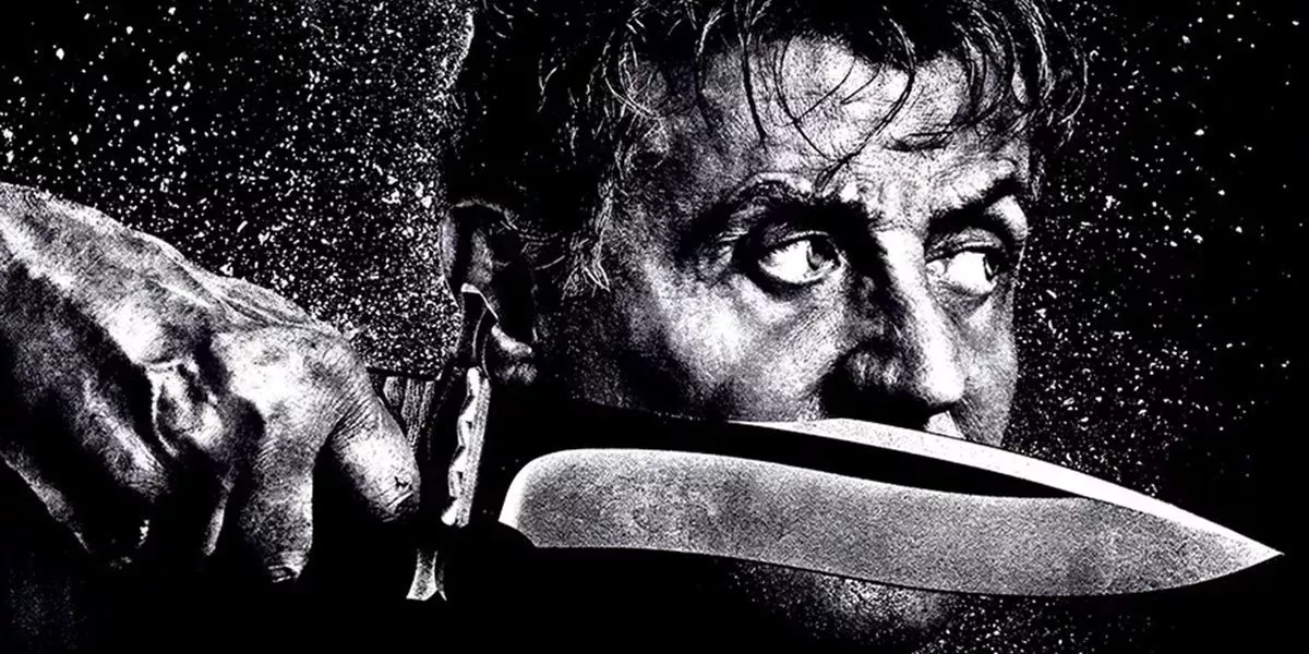 Rambo holding his bowie knife in the rain