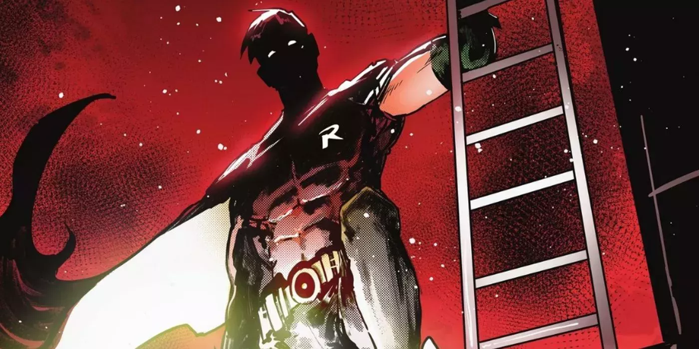 Tim Drake in his Robin costume standing next to a fire escape against a crimson-lit night sky.