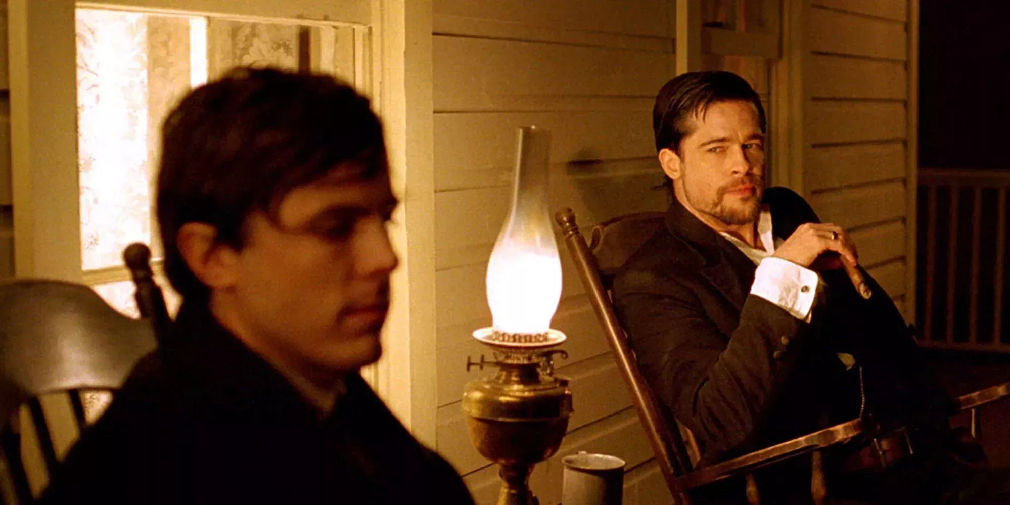 Brad Pitt sits on the porch near Casey Affleck in The Assassination Of Jesse James