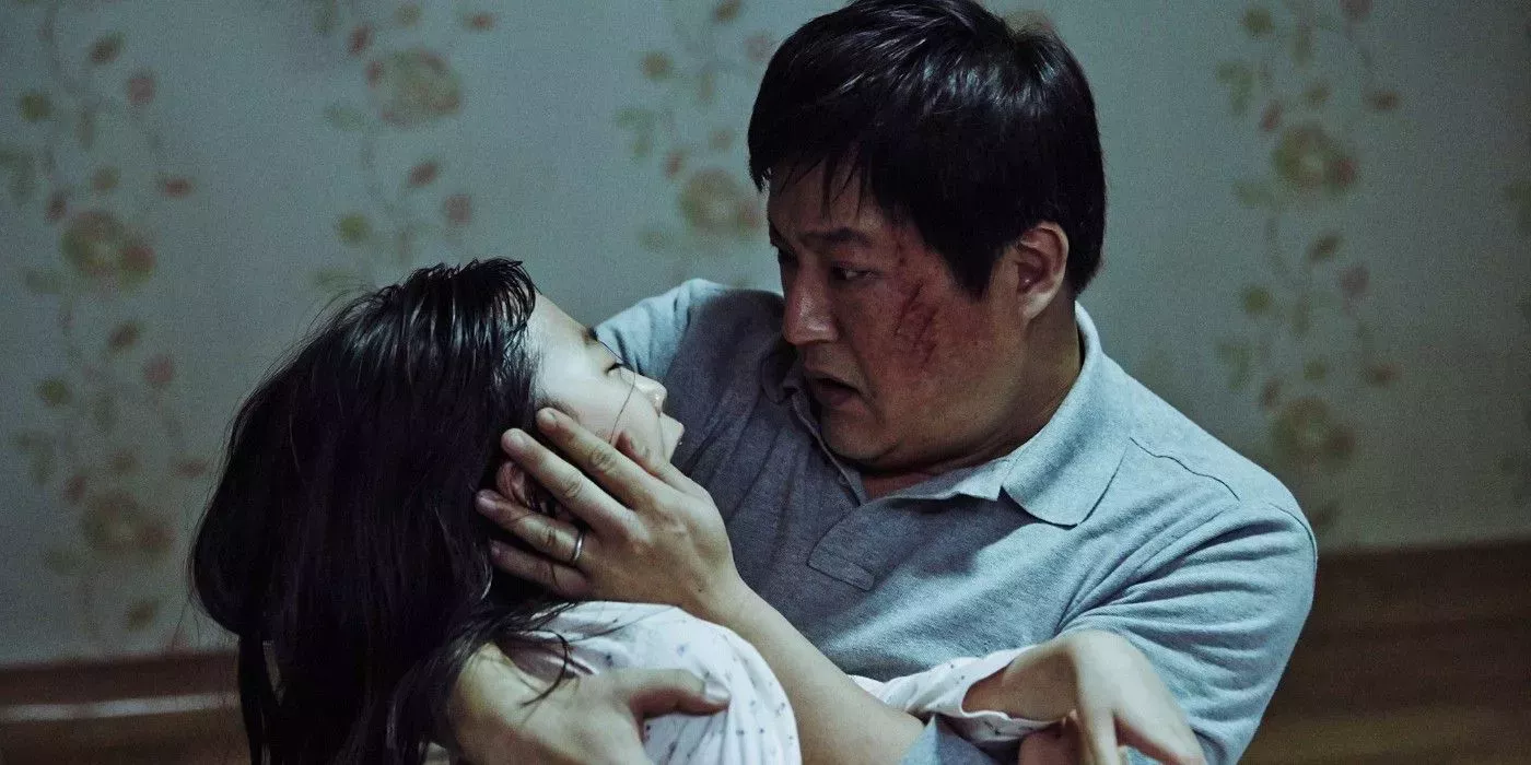 Kwak Do-won holds his daughter in the South Korean horror film The Wailing.