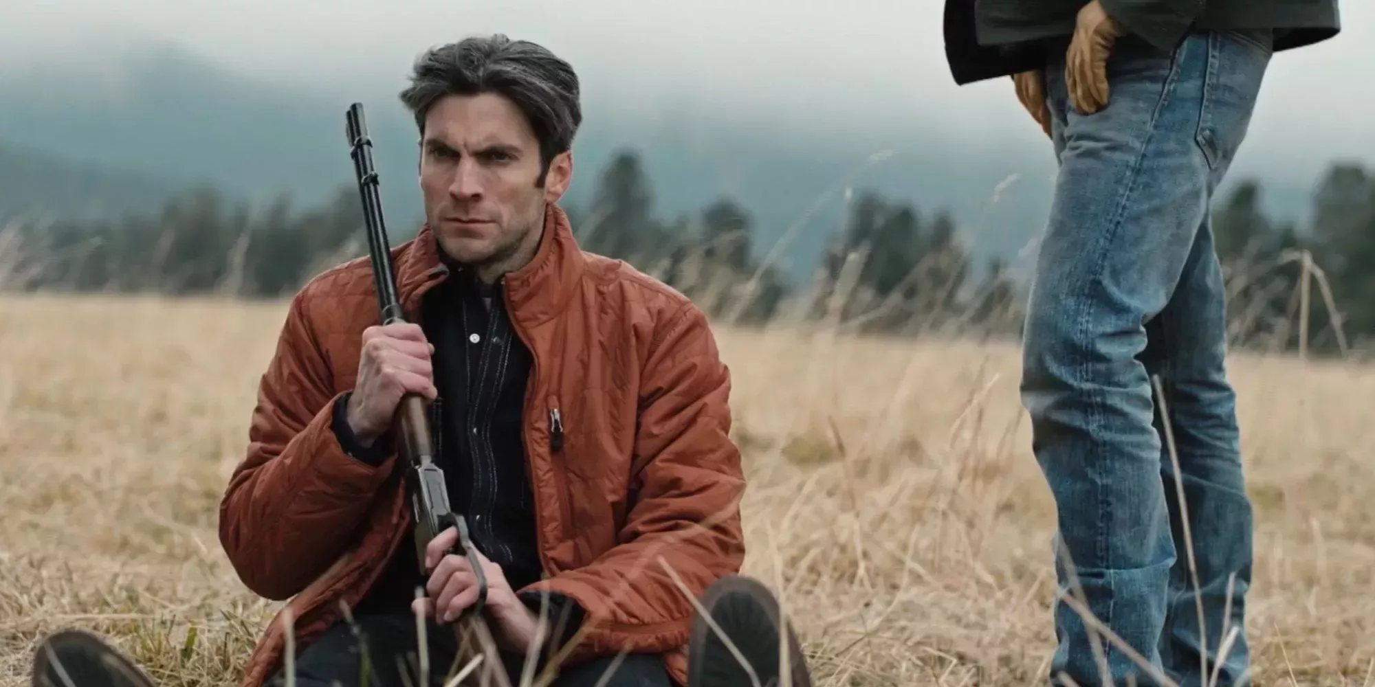 Jamie Dutton (Wes Bentley) sits in a field with a rifle
