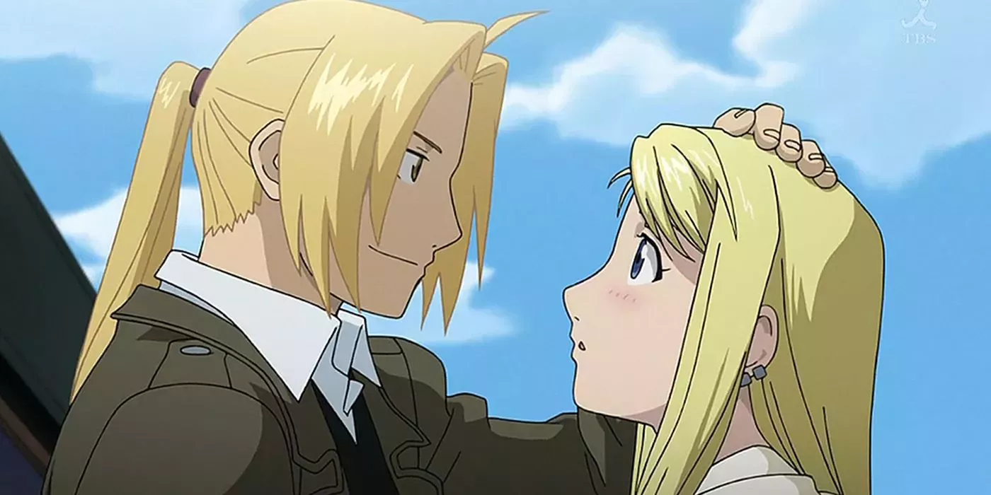 Adult Edward pats adult Winry’s head as they look at each other lovingly before Edward boards his train.