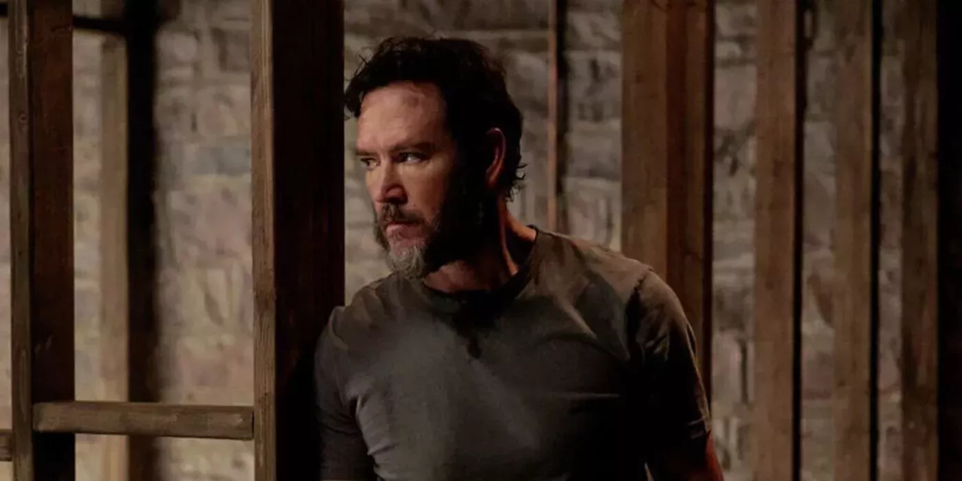 Mark-Paul Gosselaar with a beard standing in a cell looking angry in a scene from Found.