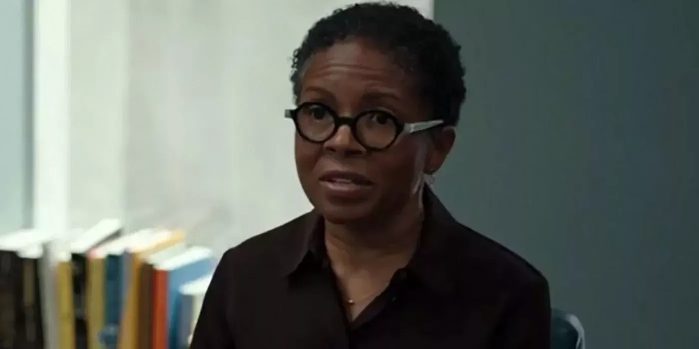 LisaGay Hamilton wearing glasses sitting in an office in The Dropout.