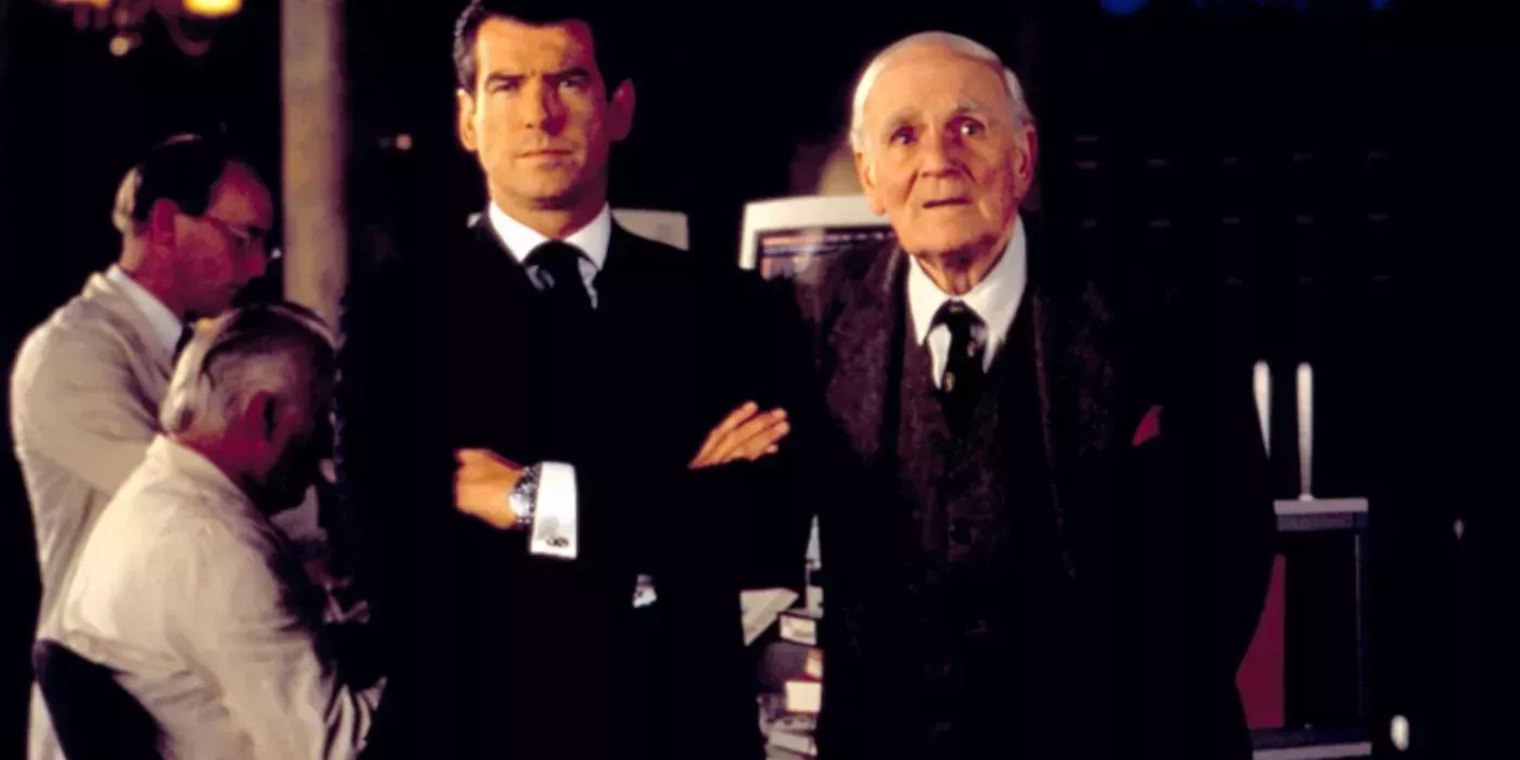 James Bond stood with his arms folded, next to Q in The World Is Not Enough