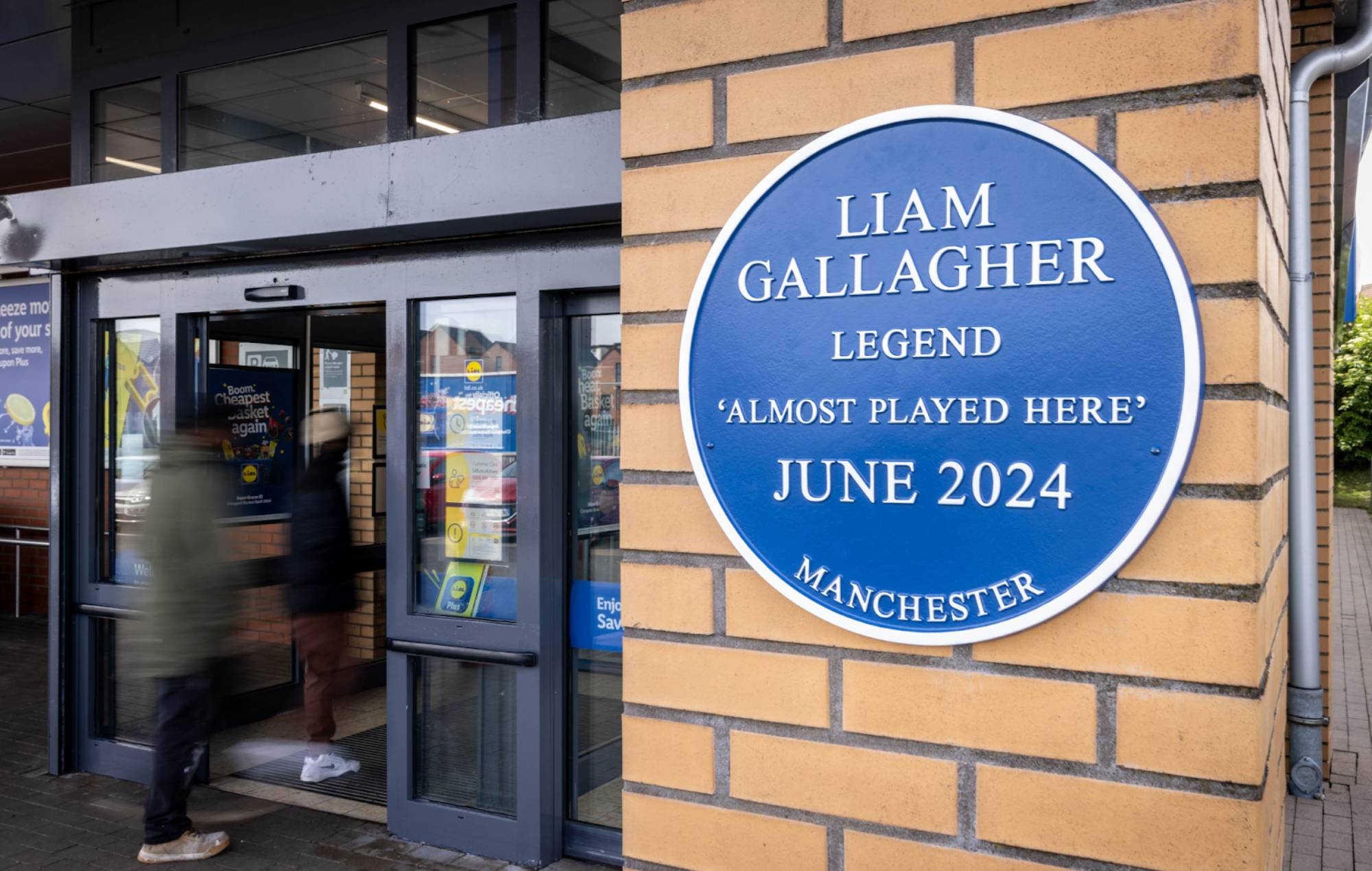 Instalan una placa azul en el Lidl de Manchester en honor a Liam Gallagher, que "casi" toca allí