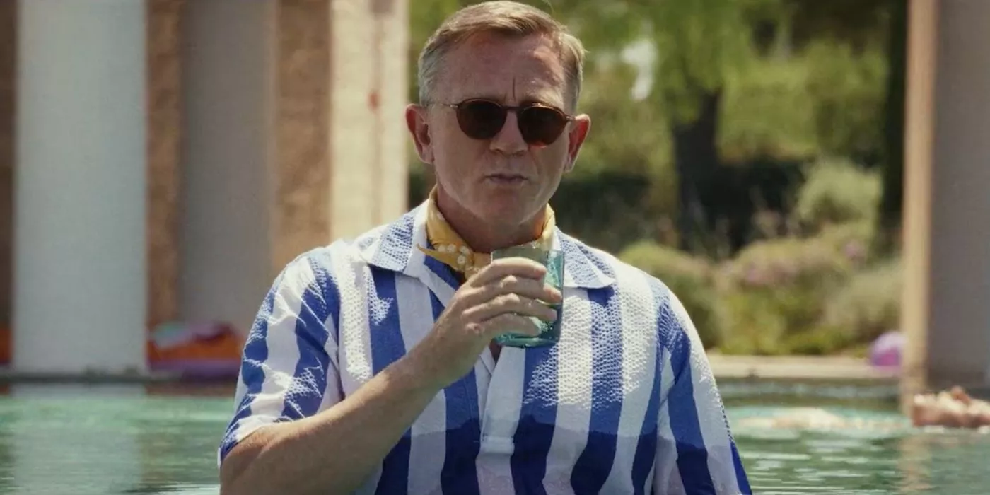 El detective Benoit Blanc de Daniel Craig se sienta en la piscina y toma una bebida en Glass Onion