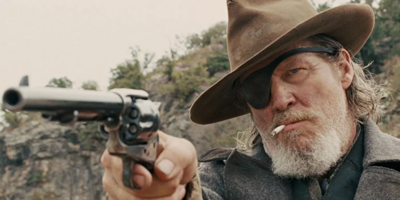 Rooster Cogburn (Jeff Bridges) points a gun at an unseen target in True Grit