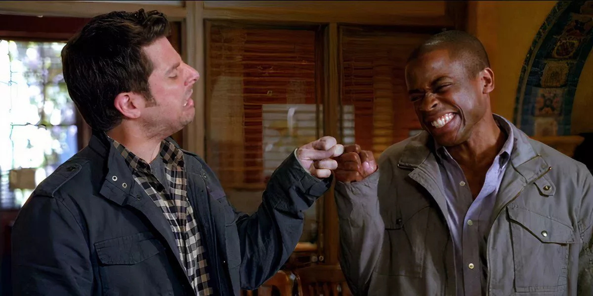 Shawn Spencer y Burton Guster se dan un choque de puños en Psych.
