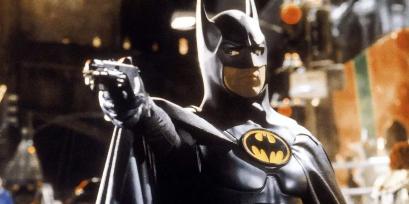 Batman holds a grapnel gun in Batman Returns.