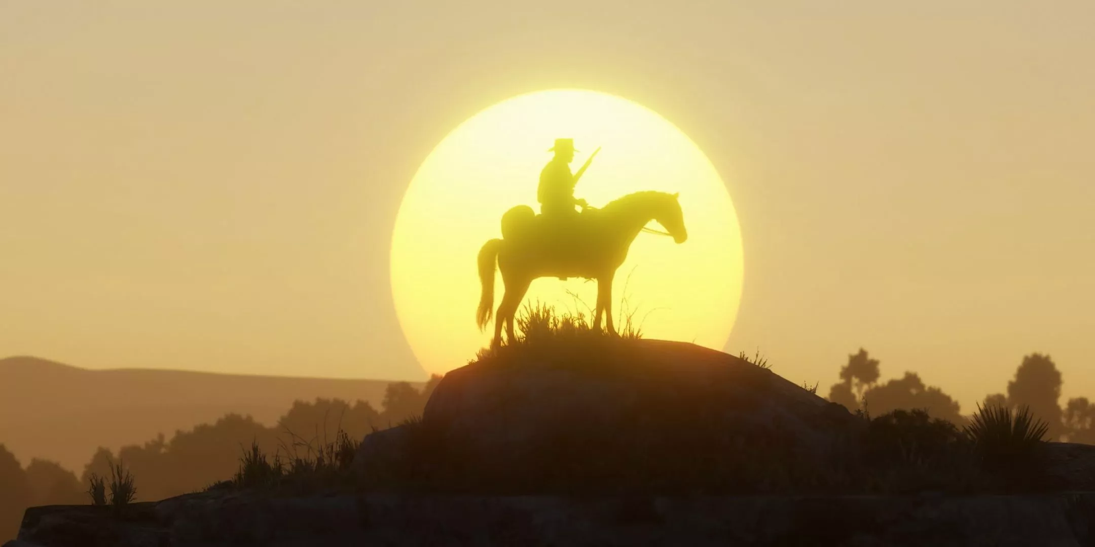 Una silueta de Arthur Morgan sobre un caballo, de pie frente a un atardecer en Red Dead Redemption 2