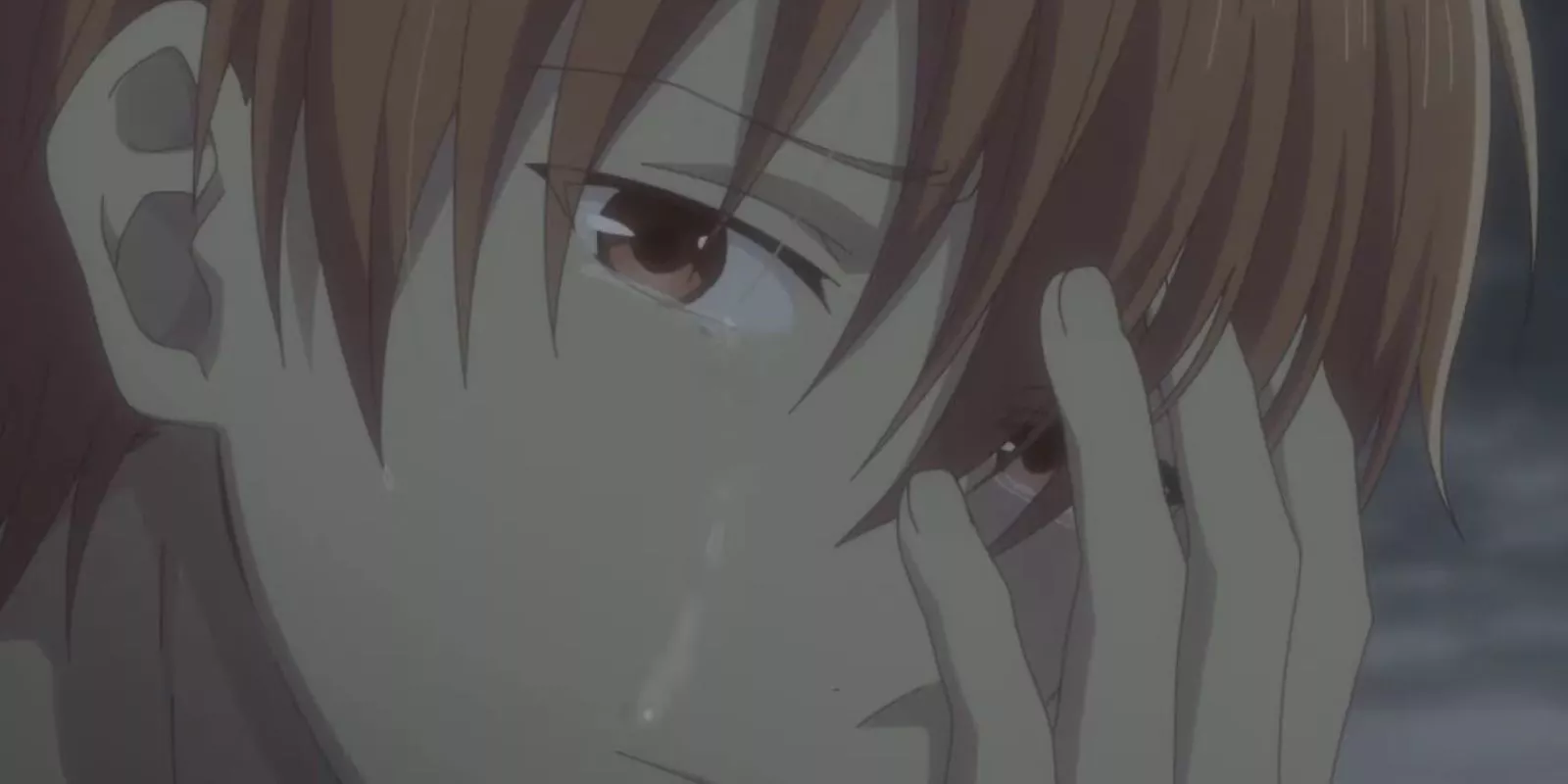 Kyo Sohma cubriendo su cara mientras una lágrima cae por su mejilla en Fruits Basket