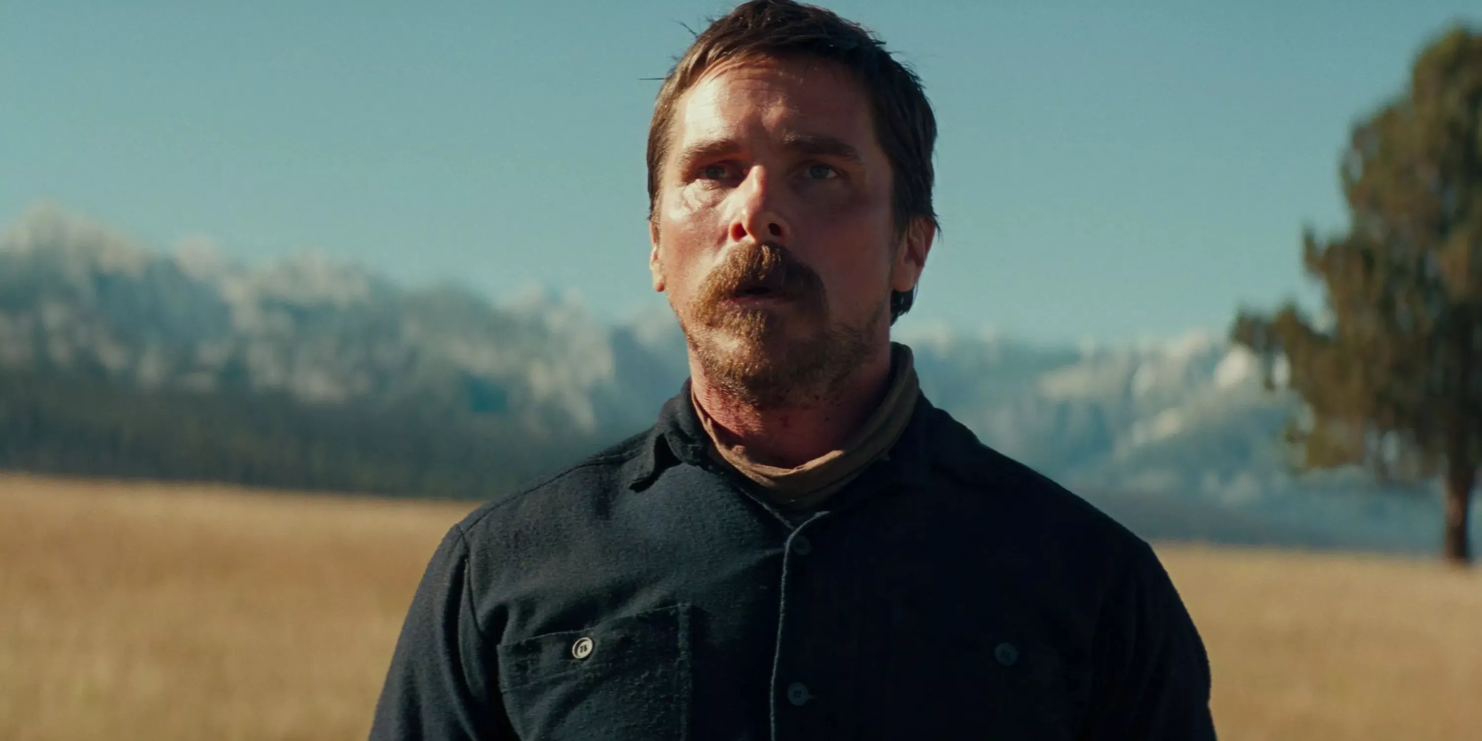 Christian Bale as Joseph Blocker standing in field in Hostiles