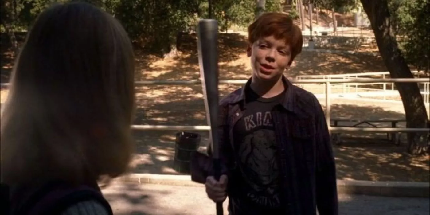 Jeffrey Charles threatens a little girl (Elle Fanning) with an aluminum bat at a park.