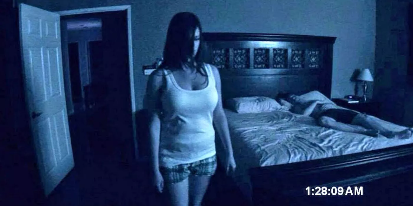 A possessed Katie standing in front of her bed at the end of Paranormal Activity.